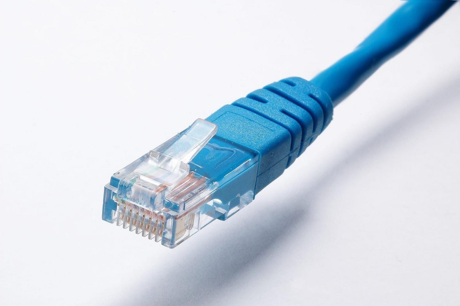 Primer plano de un conector de cable Ethernet azul, representando la conexión física necesaria para flashear el router.