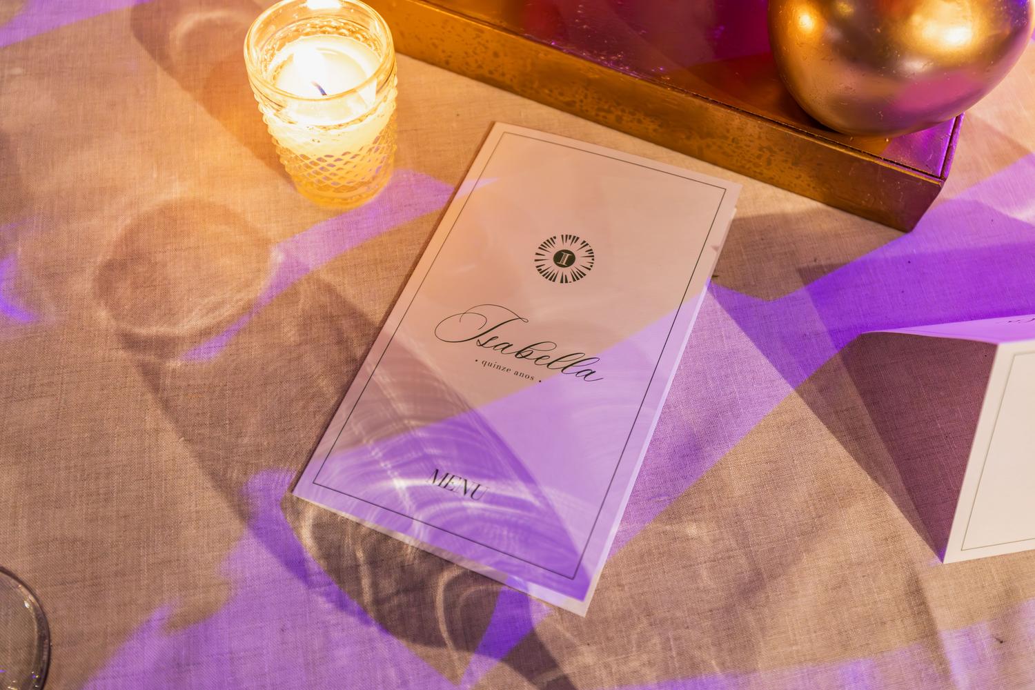 Detalle de un menú elegante en una mesa de restaurante de lujo con iluminación tenue y velas.