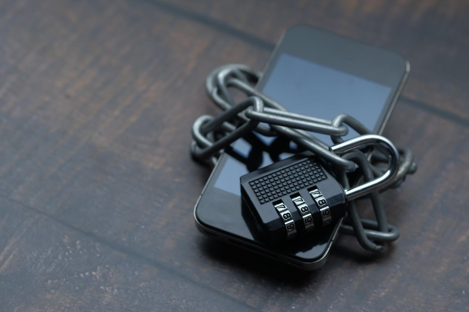 Smartphone asegurado con una cadena y un candado, simbolizando la protección de datos y la privacidad de las aplicaciones. Smartphone asegurado con una cadena y un candado, simbolizando la protección de datos y la privacidad de las aplicaciones.