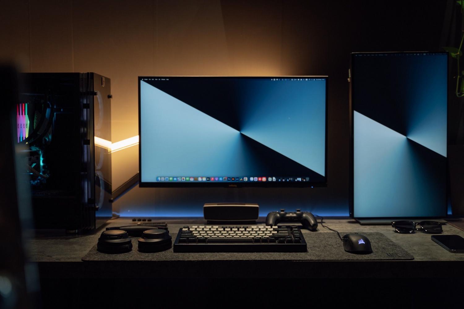 Setup moderno de ordenador con doble pantalla y accesorios gaming