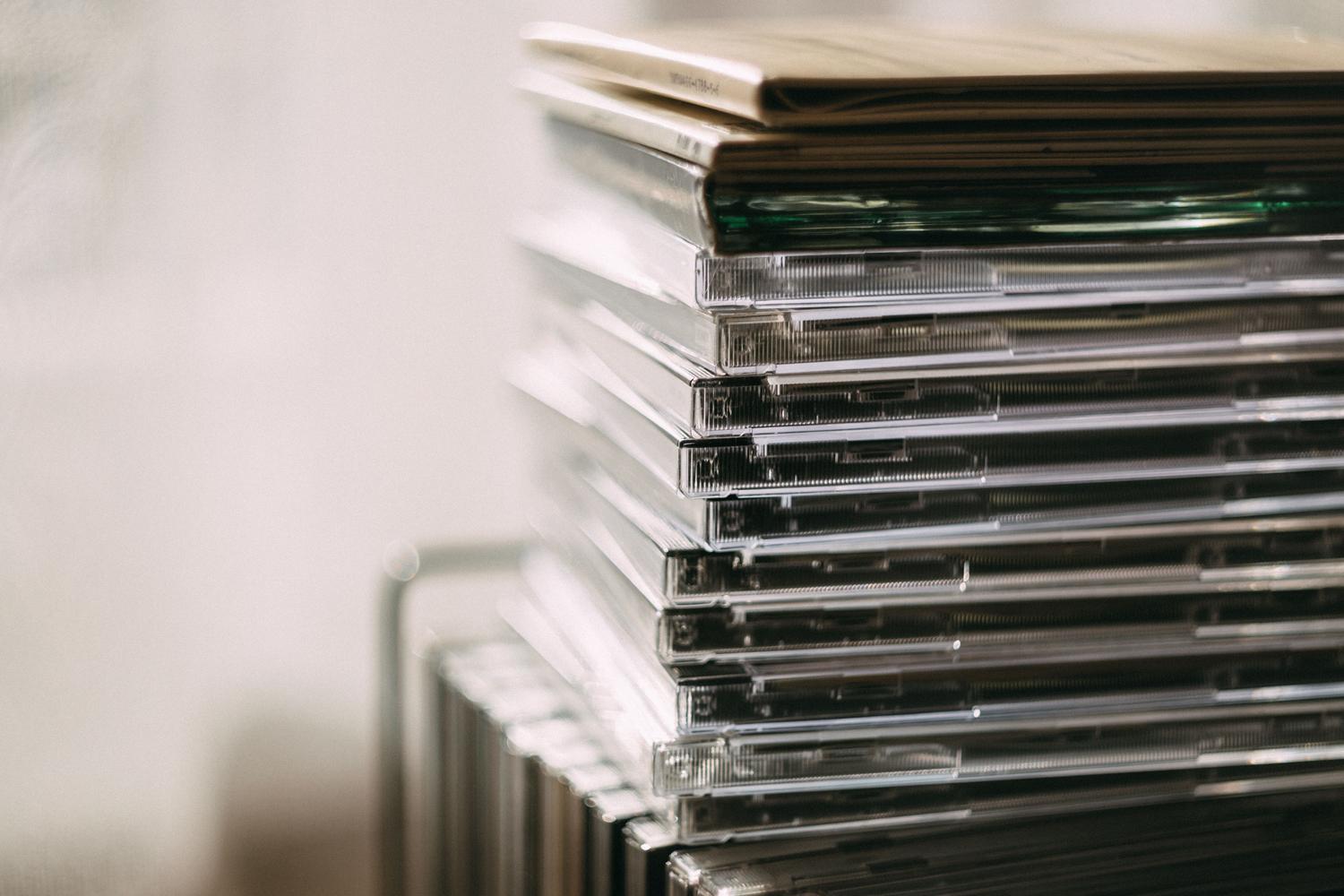 Una pila de cajas de CDs transparentes, representando la colección de música física previa a la digitalización.