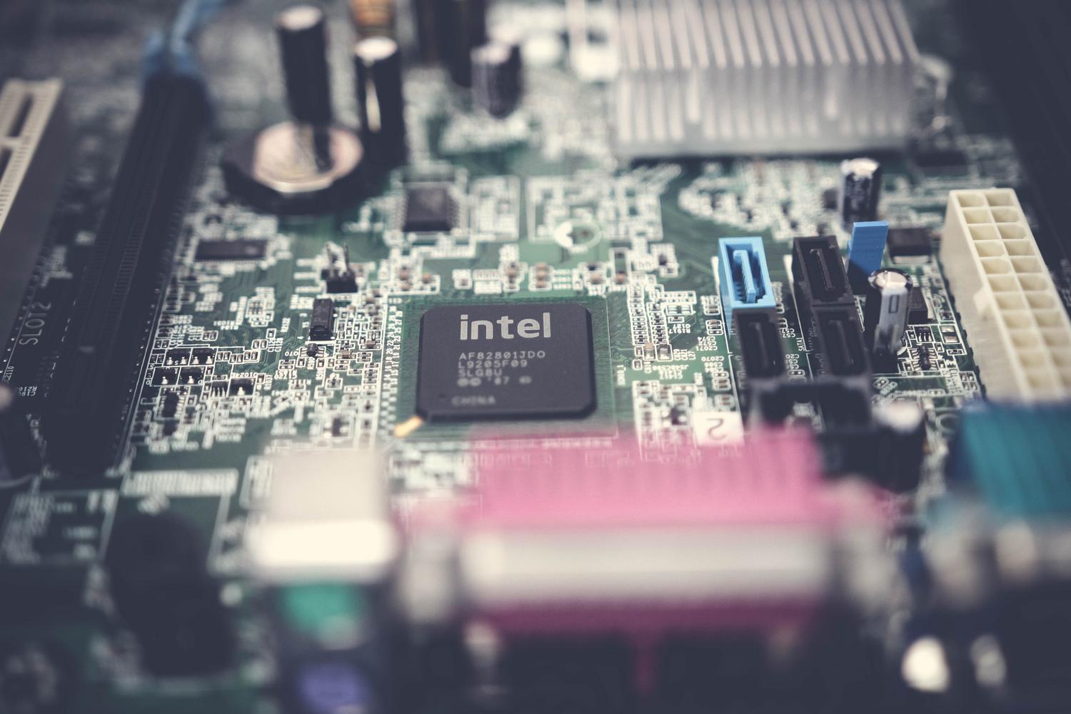 Detalle de una placa base de ordenador resaltando los componentes electrónicos y puertos SATA para almacenamiento SSD.