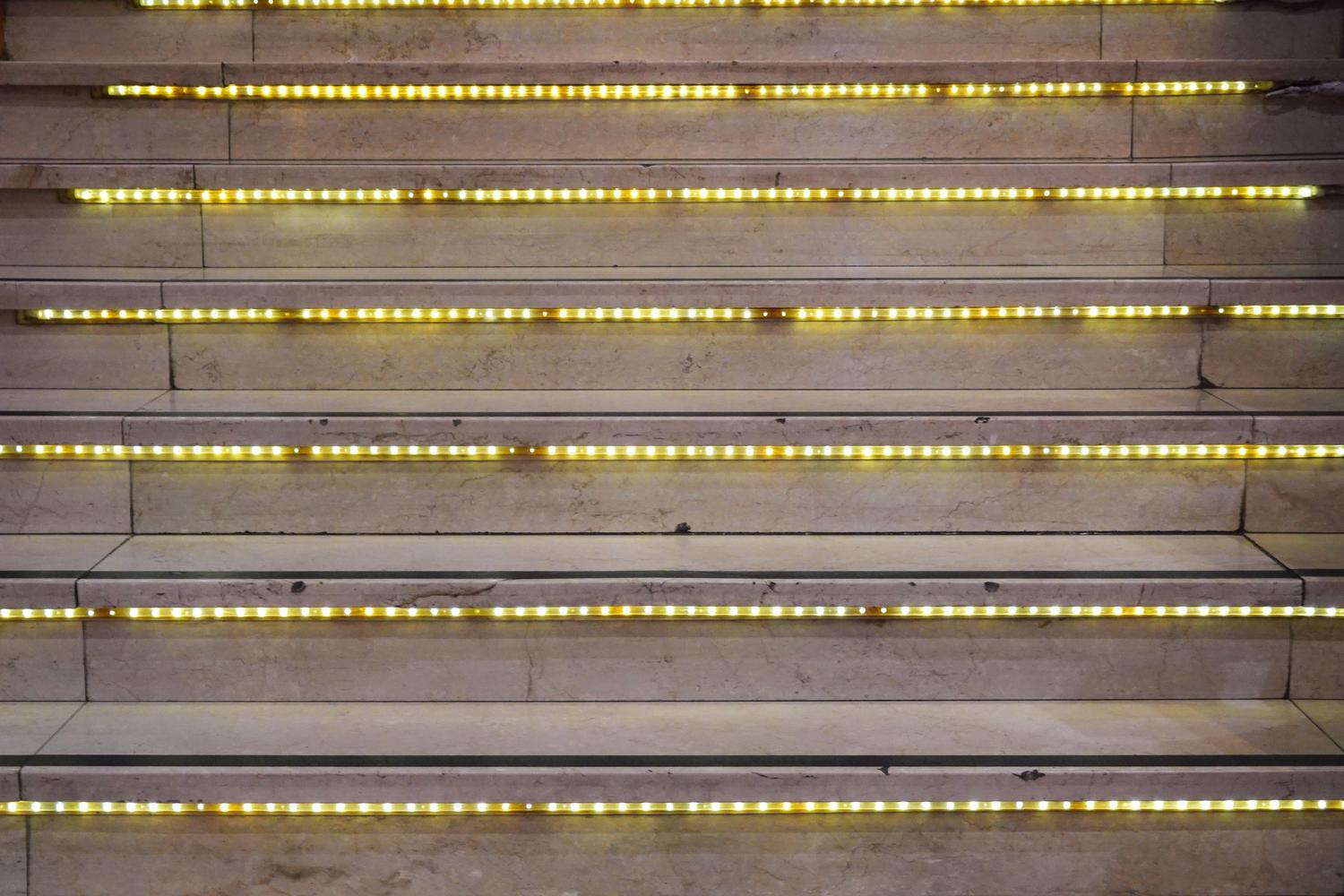 Instalación de tiras LED modernas integradas en los escalones de una escalera para iluminación arquitectónica