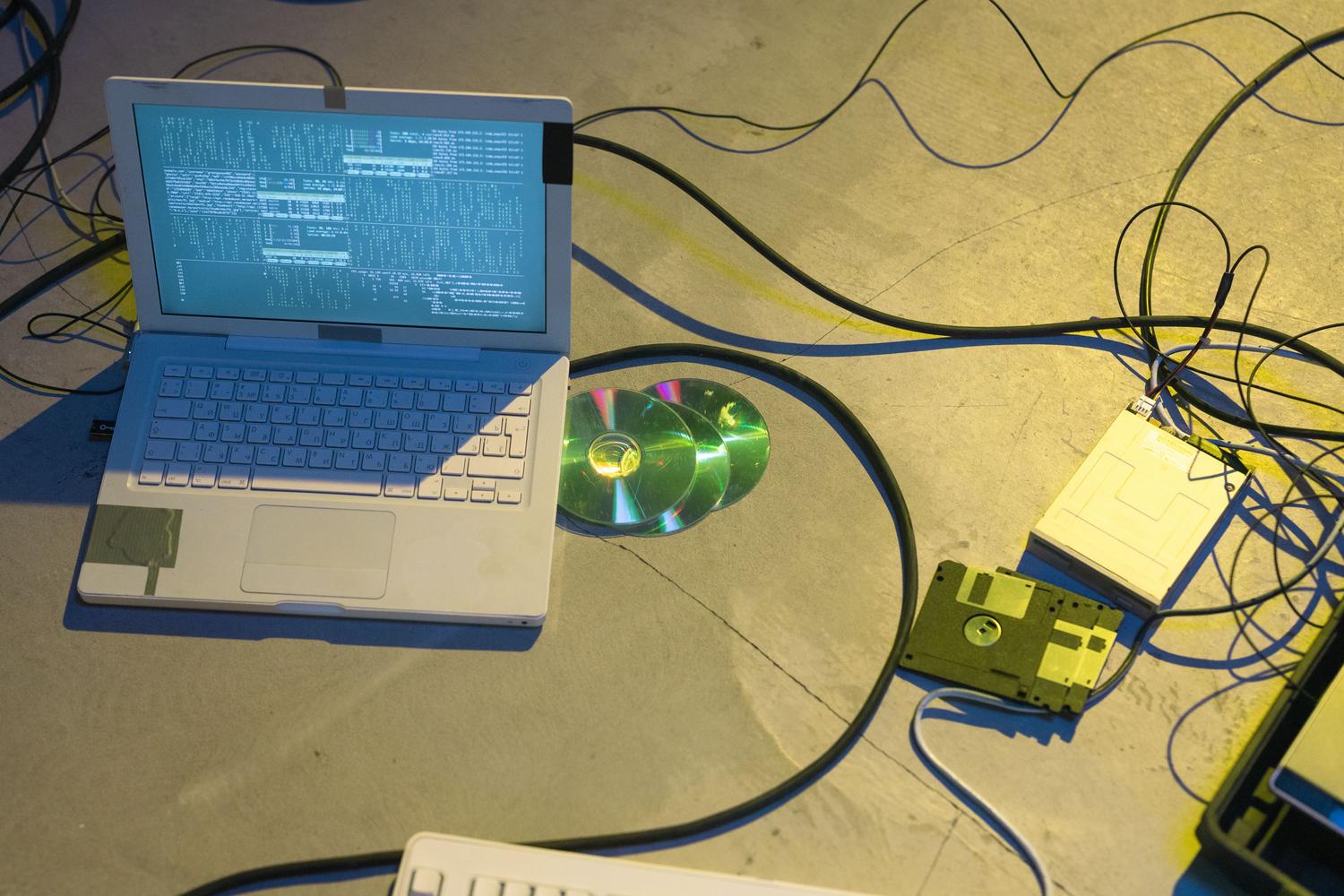 Vista cenital de un equipo informático antiguo con cables y discos, ilustrando los PCs que no cumplen los requisitos oficiales de Windows 11. Vista cenital de un equipo informático antiguo con cables y discos, ilustrando los PCs que no cumplen los requisitos oficiales de Windows 11.
