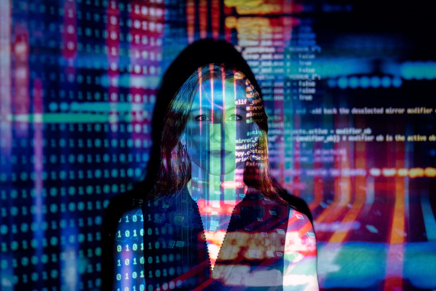 Proyección de código digital sobre el rostro de una persona, ilustrando la naturaleza técnica de la IA y la necesidad de transparencia.
