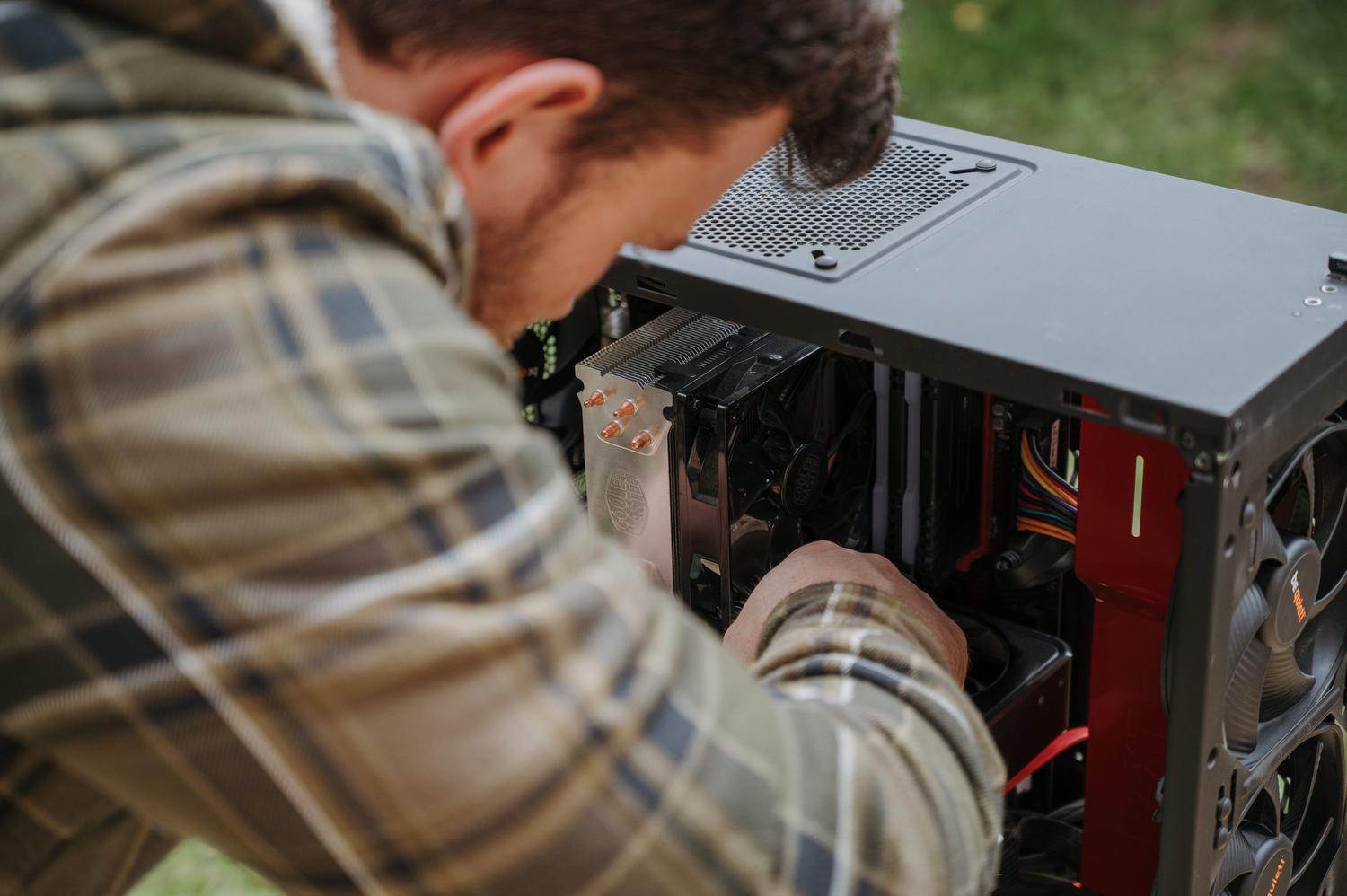 Hombre realizando el mantenimiento y limpieza de un PC de escritorio
