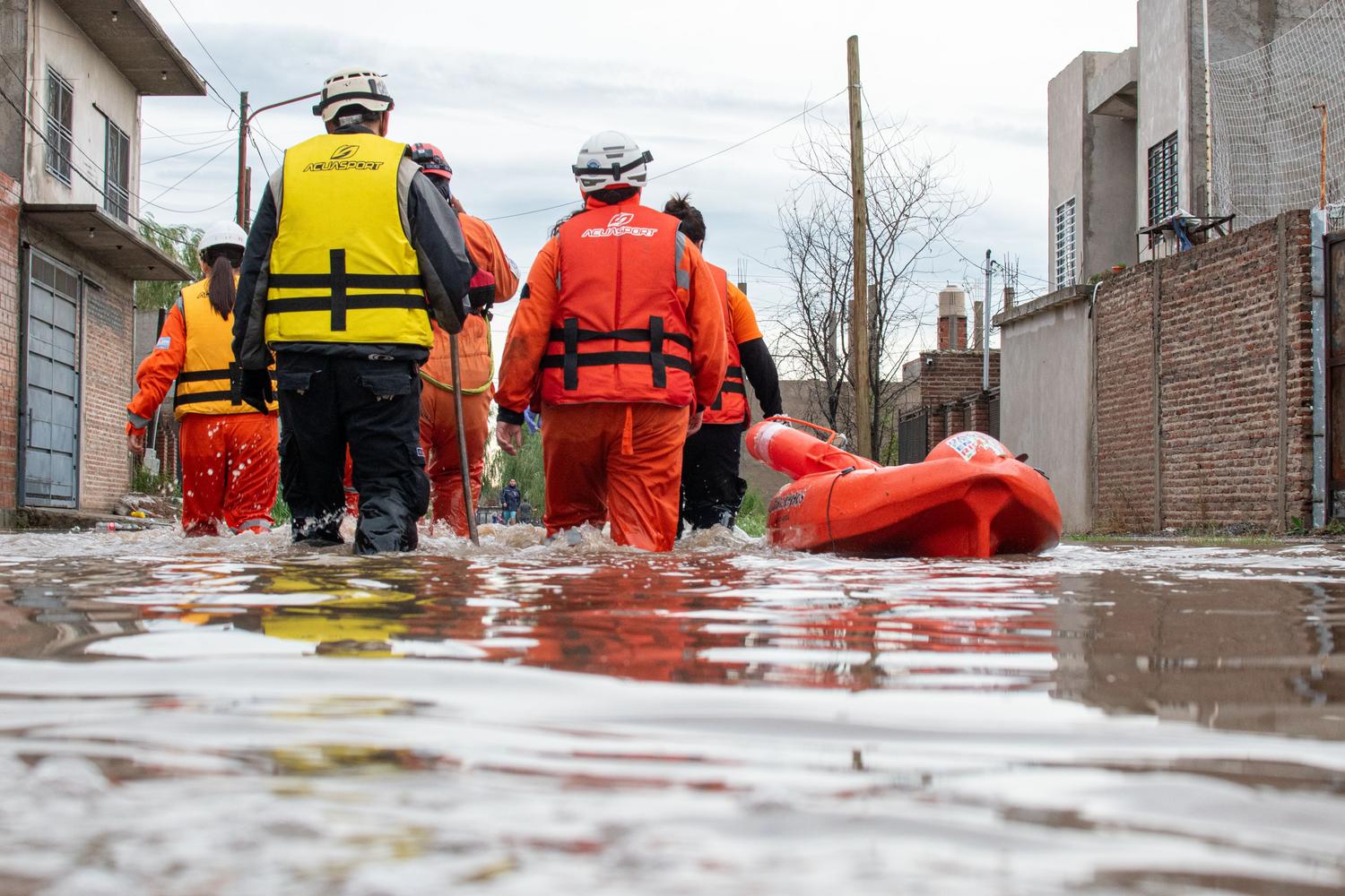 Equipo de rescate especializado navegando por una calle inundada durante una emergencia climática.
