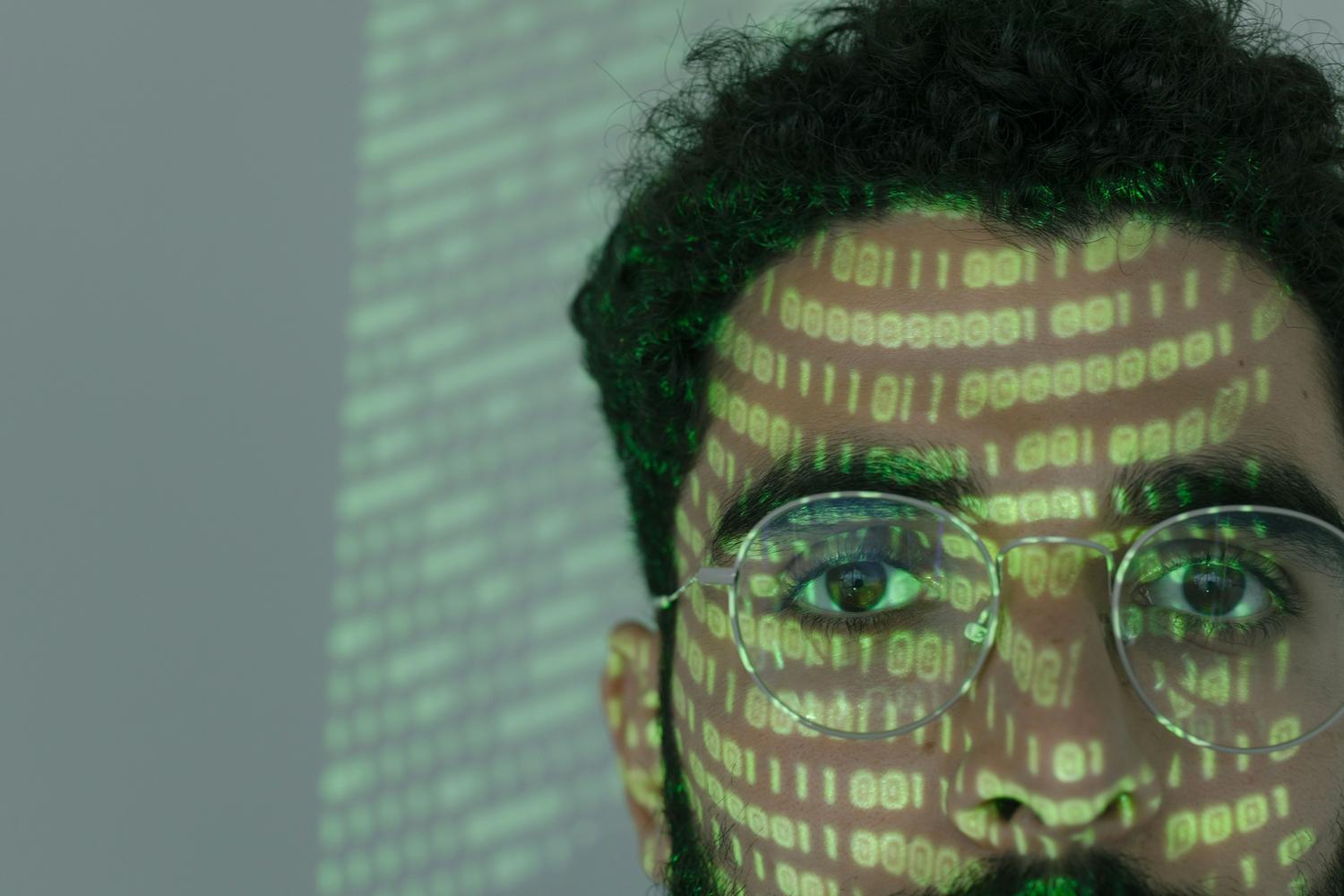 Representación visual de la ciberseguridad con código binario proyectado, destacando la importancia de la privacidad y seguridad de los datos en aplicaciones de IA.