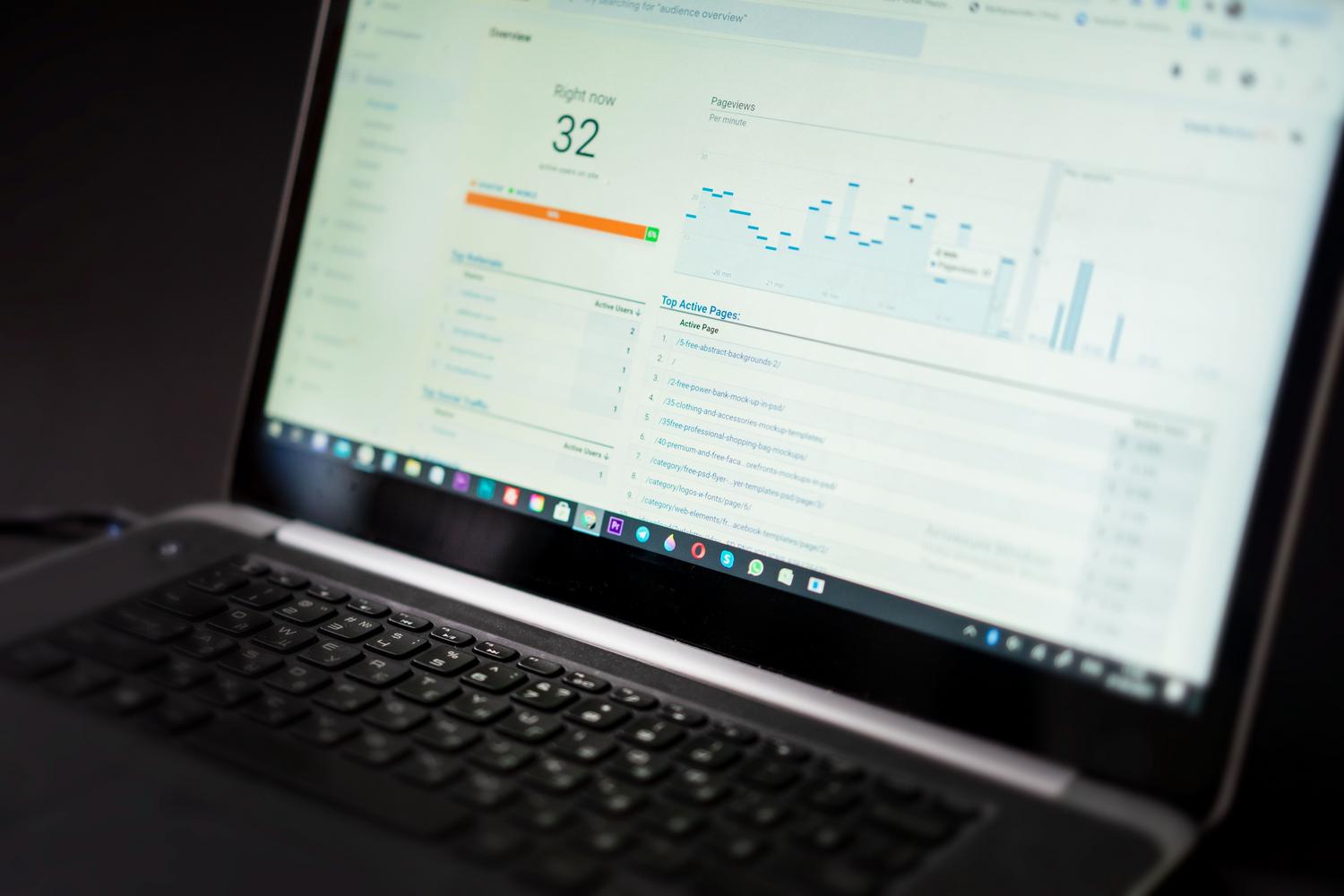 Laptop mostrando un panel de control con gráficas de análisis de datos en tiempo real.
