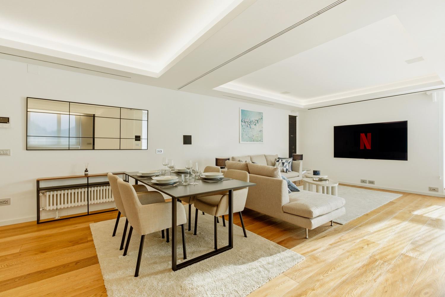 Salón moderno y luminoso con un televisor de gran formato mostrando Netflix, representando el consumo doméstico de contenidos Ultra HD.