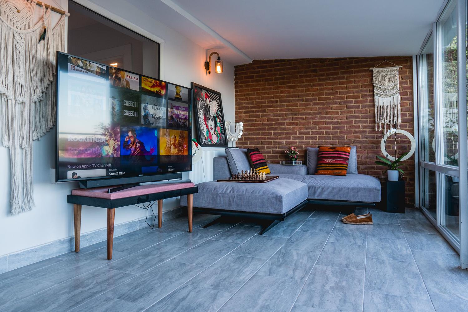 Salón moderno y elegante con una televisión de pantalla plana integrada en la decoración, ideal para mostrar el uso de aplicaciones de cliente de Plex.