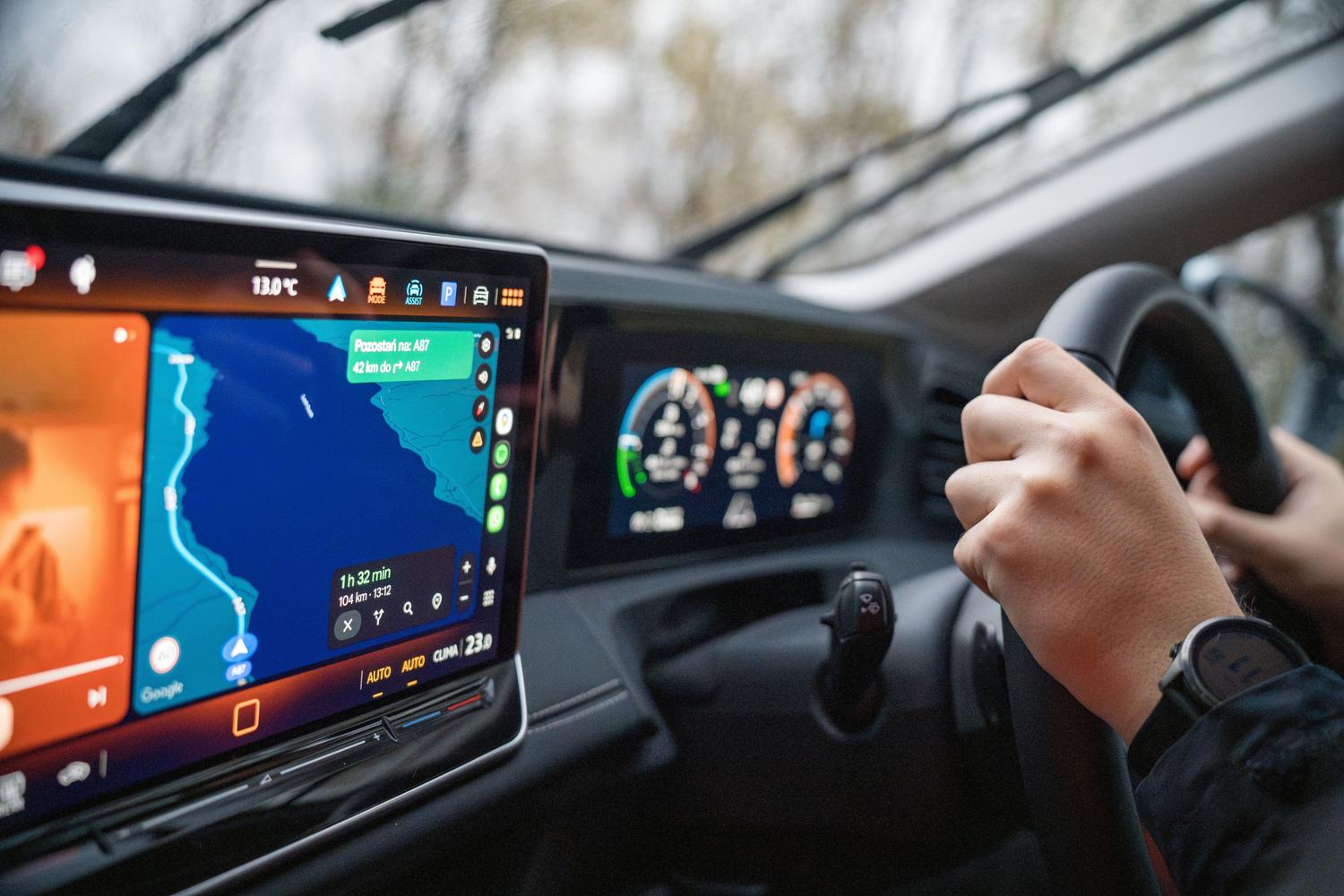 Manos al volante y sistema de navegación GPS en la pantalla del coche, representando el uso de Android Auto.
