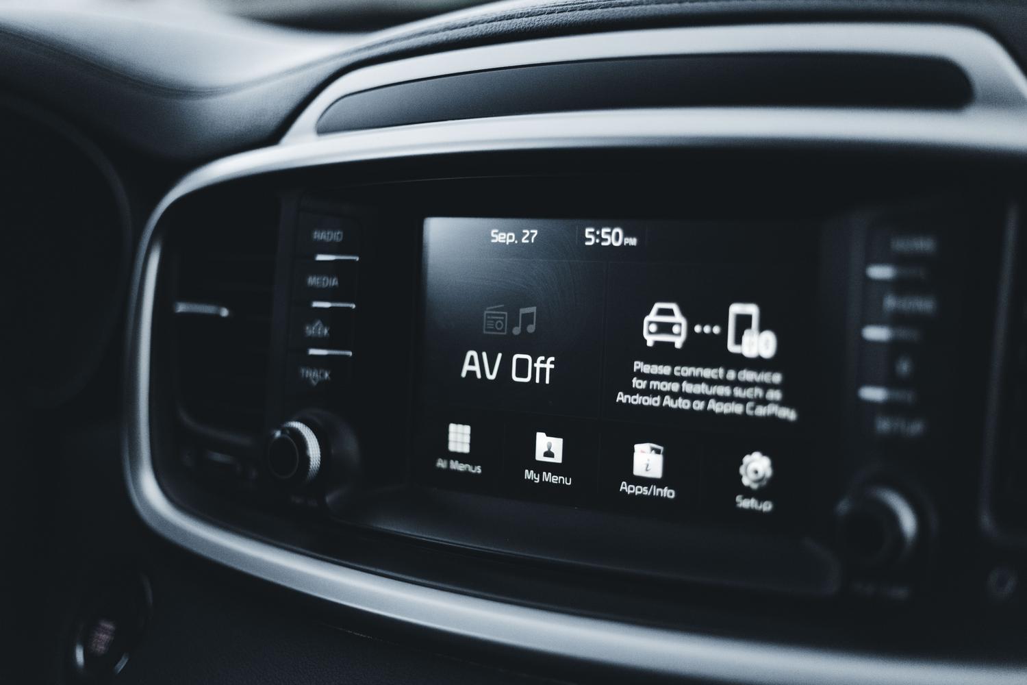 Primer plano detallado de la pantalla de un salpicadero de coche moderno mostrando opciones tecnológicas.