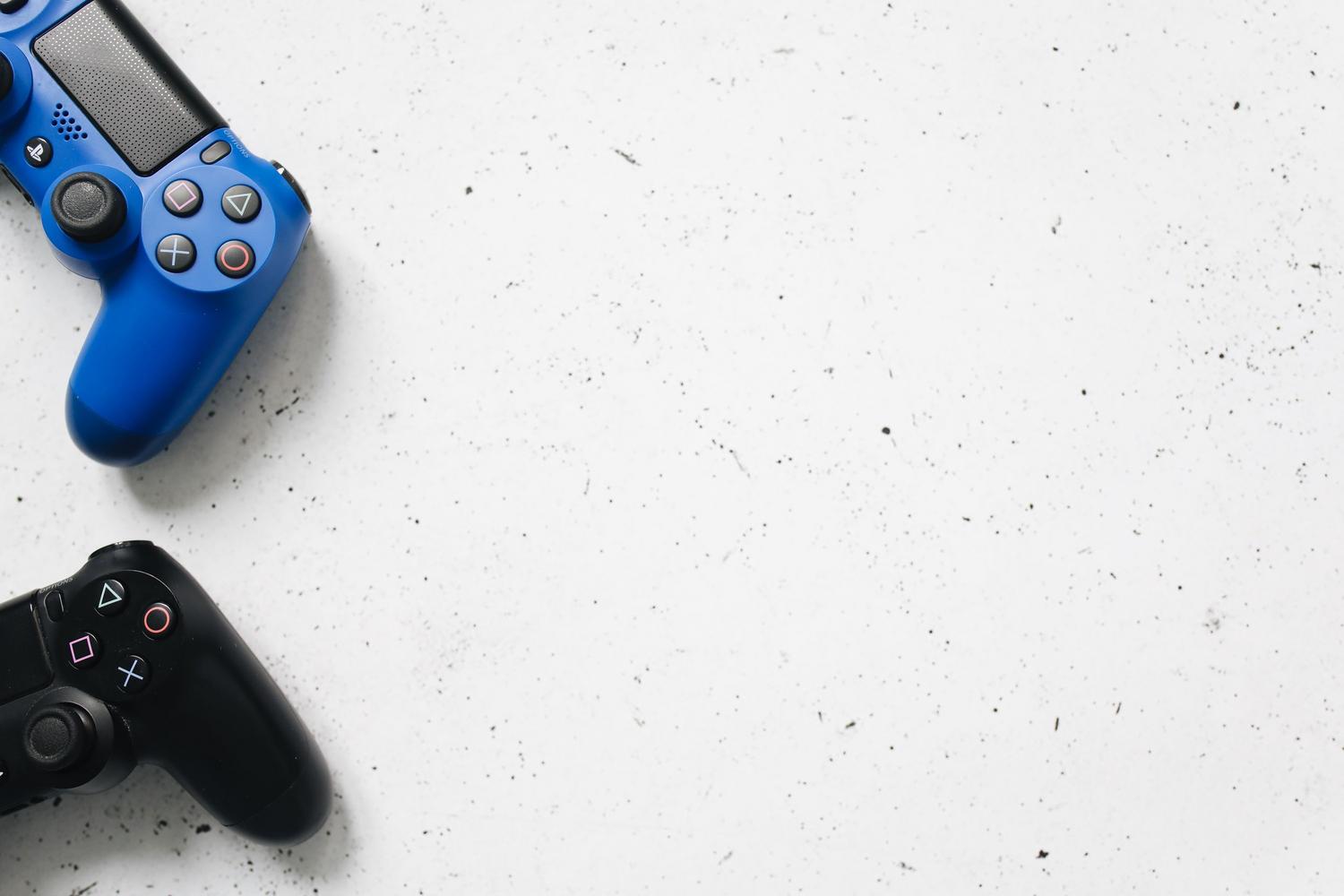 Mandos de PlayStation en azul y negro sobre fondo blanco, ilustrando el ecosistema y la interacción del usuario con la consola. Mandos de PlayStation en azul y negro sobre fondo blanco, ilustrando el ecosistema y la interacción del usuario con la consola.