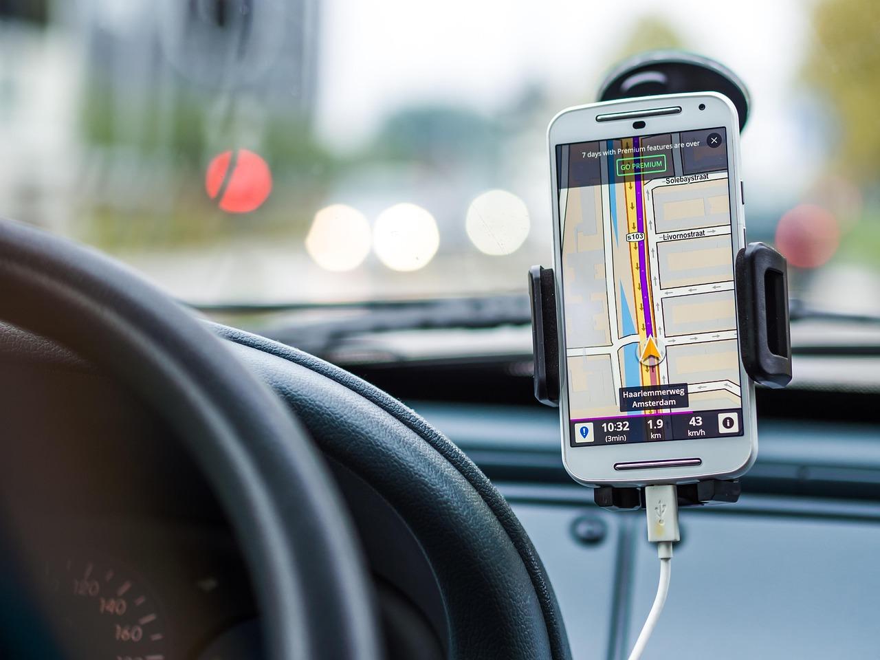 Smartphone con aplicación de navegación GPS activa montado en un coche, ejemplificando el alto consumo energético de las apps de mapas.