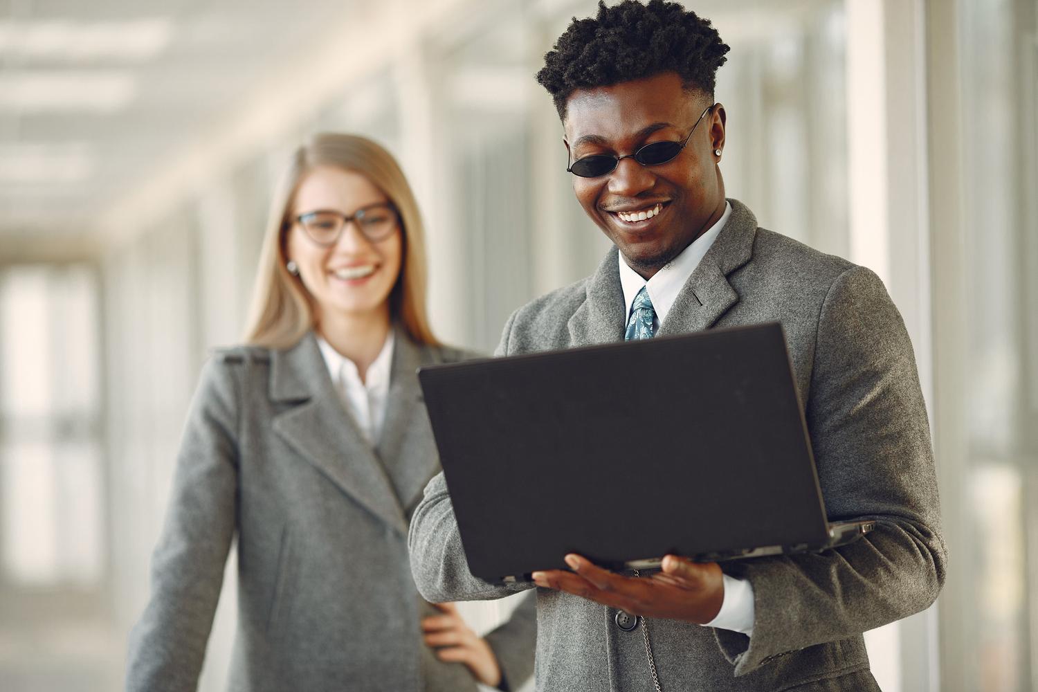 Profesionales utilizando portátiles de gama empresarial en un entorno de oficina moderno, representando la durabilidad de los equipos corporativos.