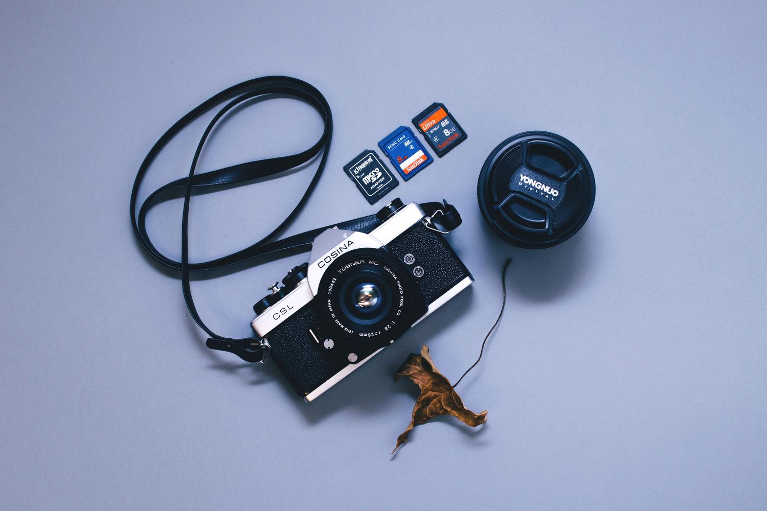 Cámara fotográfica clásica junto a tarjetas de memoria modernas, vinculando el problema de la recuperación de archivos con la fotografía digital. Cámara fotográfica clásica junto a tarjetas de memoria modernas, vinculando el problema de la recuperación de archivos con la fotografía digital.