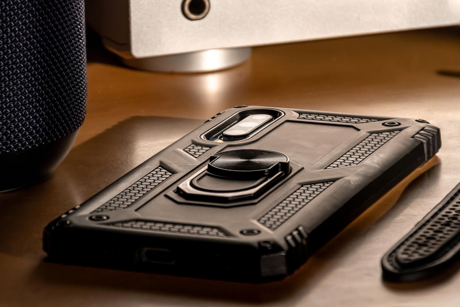 Smartphone equipado con una funda robusta y protectora sobre un escritorio.