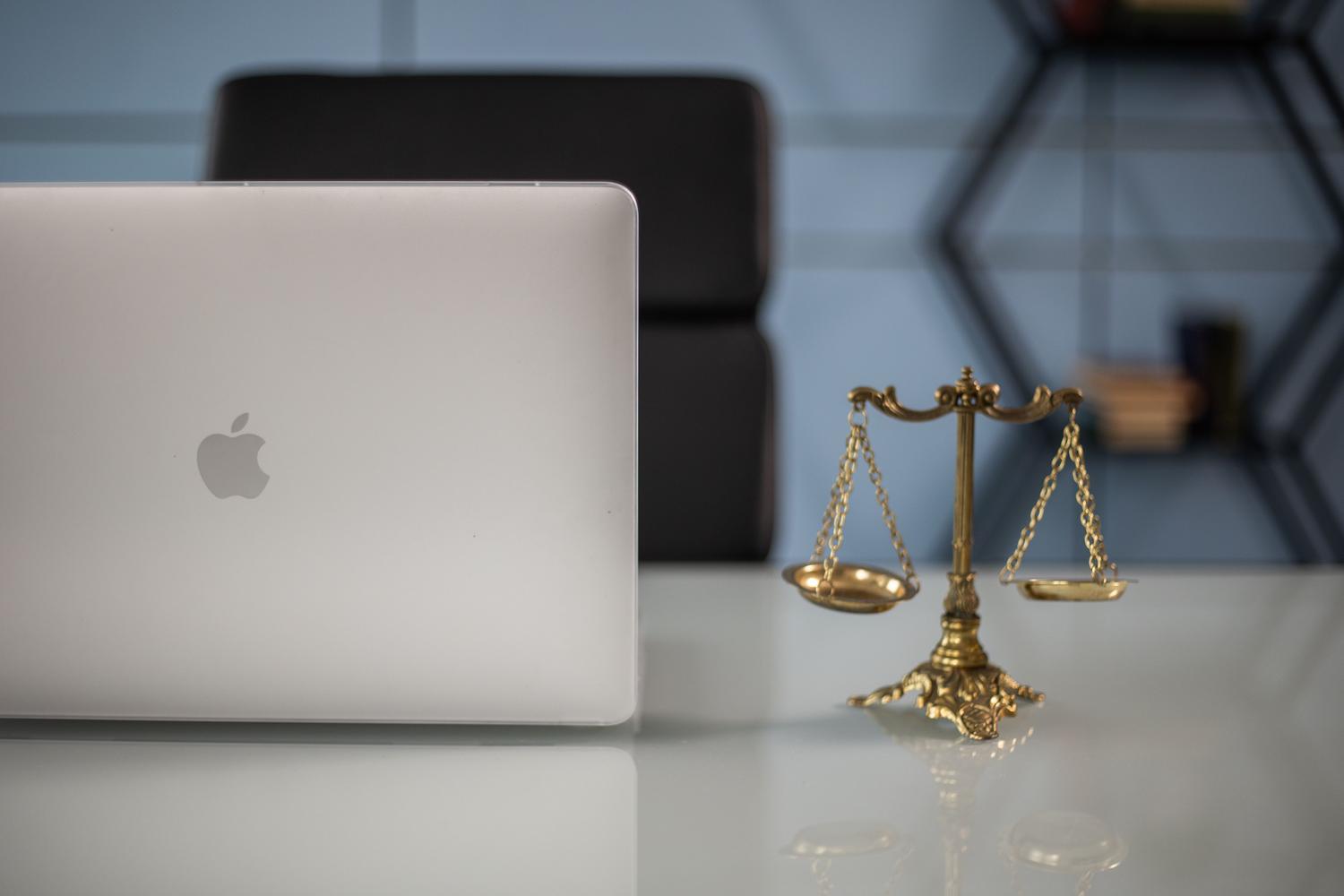 Equilibrio entre la tecnología digital y la justicia legal sobre un escritorio.