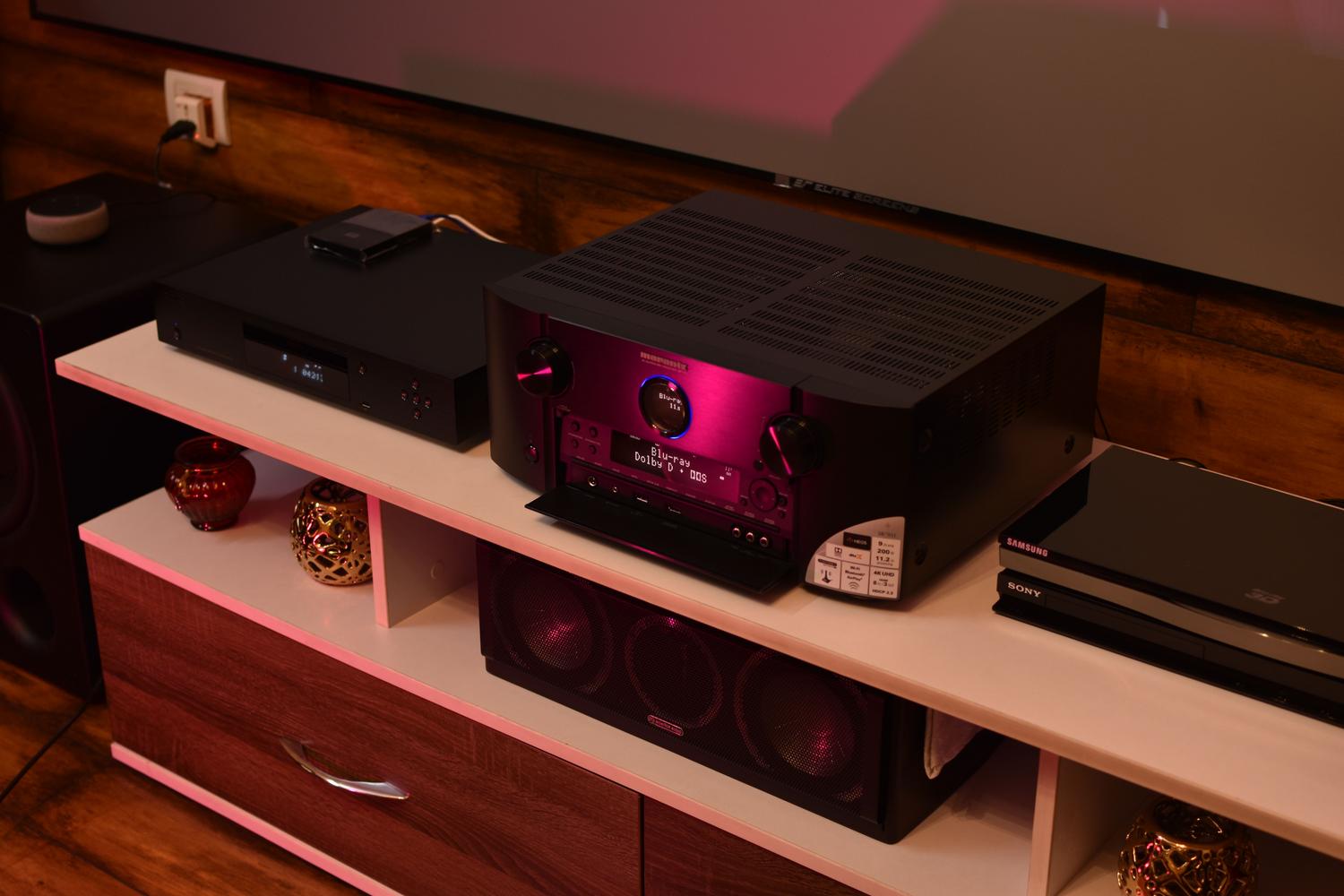 Configuración de sistema de sonido envolvente con receptor Marantz y subwoofer, ilustrando la integración de equipos de audio premium.