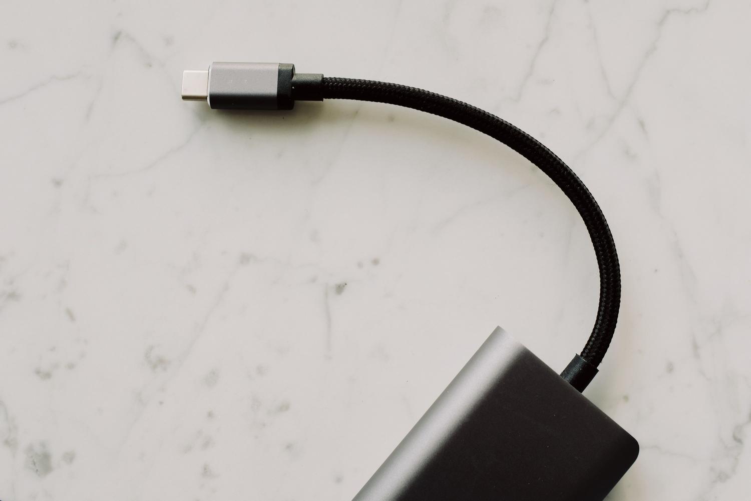 Cable USB-C de alta calidad con conector metálico sobre fondo de mármol blanco, ideal para ilustrar la tecnología USB4 Cable USB-C de alta calidad con conector metálico sobre fondo de mármol blanco, ideal para ilustrar la tecnología USB4