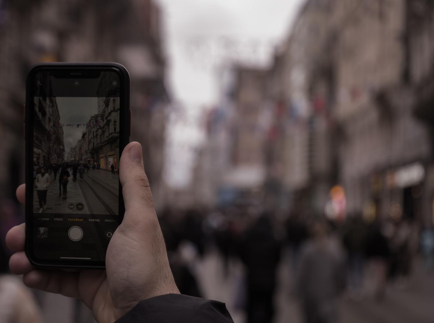 Vista en primera persona de un smartphone enfocando una calle urbana, ejemplificando la función de traducción visual Word Lens del Traductor de Google.