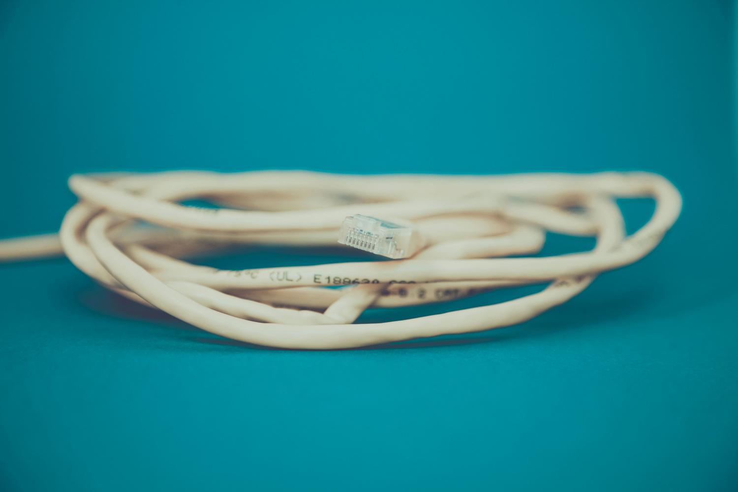 Primer plano de un conector RJ-45 de cable Ethernet, elemento fundamental para medir la velocidad de conexión LAN. Primer plano de un conector RJ-45 de cable Ethernet, elemento fundamental para medir la velocidad de conexión LAN.
