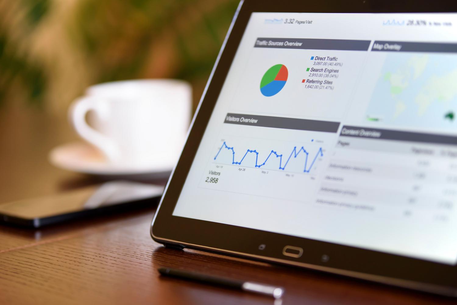 Dashboard de visualización de KPIs de negocio en una tablet sobre un escritorio, transformando telemetría en decisiones.