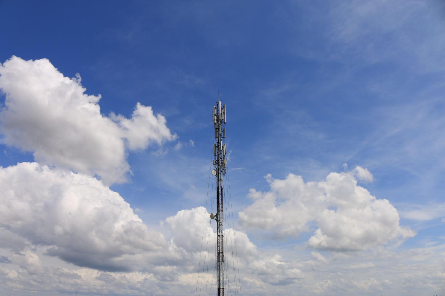 Torre de comunicaciones bajo un cielo azul, simbolizando la conectividad inalámbrica 5G y LTE para sedes remotas.