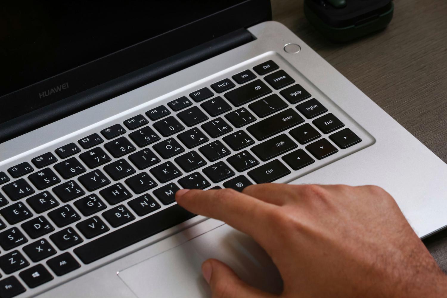 Primer plano de manos utilizando el teclado de un portátil para ejecutar atajos de teclado.