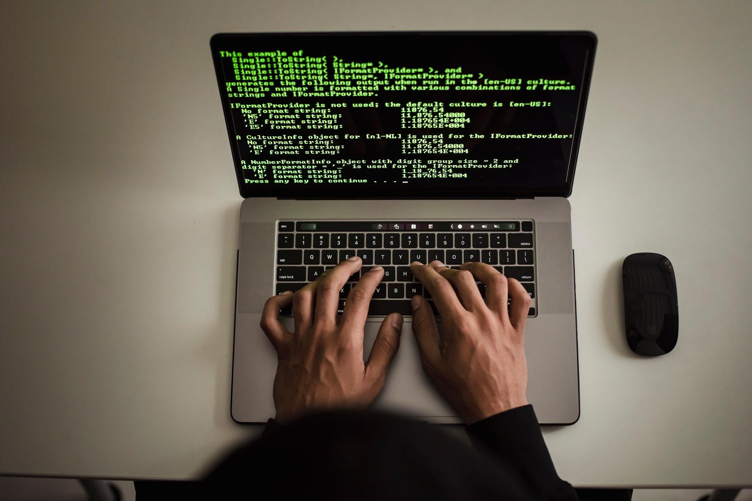 A developer working on a laptop in a modern workspace, focusing on technical writing.