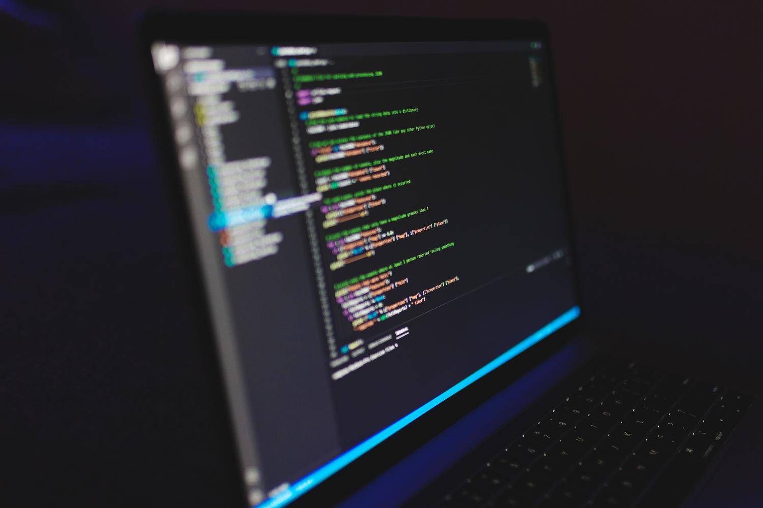 Laptop displaying code in a dark environment, highlighting the digital nature of Markdown files.