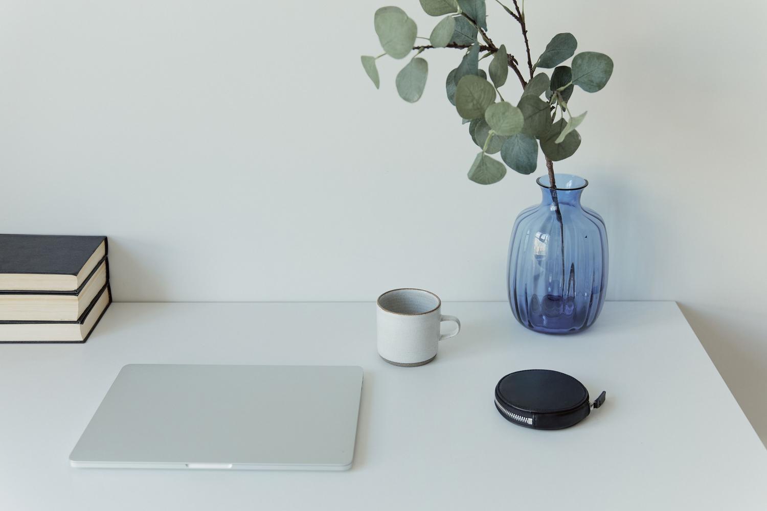 Escritorio blanco minimalista y moderno con un portátil cerrado, evocando un entorno de trabajo digital limpio y actualizado.
