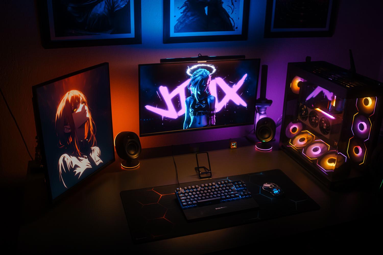 Setup de gaming avanzado con monitor principal y secundario vertical, destacando colores vibrantes y negros profundos similares al efecto HDR.
