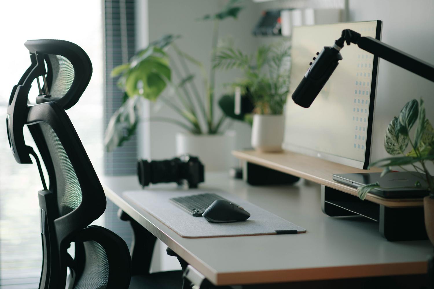 Espacio de trabajo moderno y luminoso con silla ergonómica y luz natural, representando un entorno saludable y cómodo para la visión.