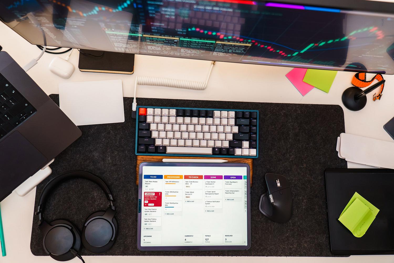 Vista cenital de un escritorio minimalista con teclado mecánico y tablet organizando tareas digitales, ideal para la sección de administración y programación de tareas.