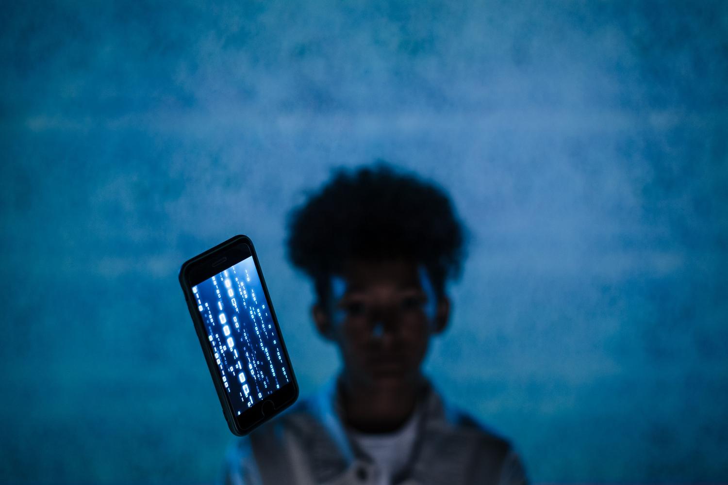 Privacidad digital y bloqueo de chats en ChatGPT Imagen conceptual de privacidad digital con un smartphone y código abstracto sobre un fondo azul.