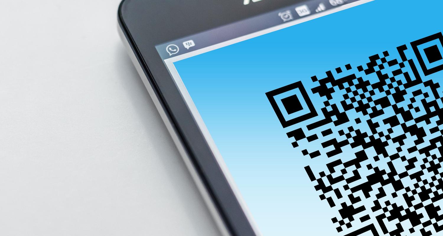 Primer plano de un smartphone mostrando un código QR en pantalla, ideal para representar la generación de una clave de WiFi.