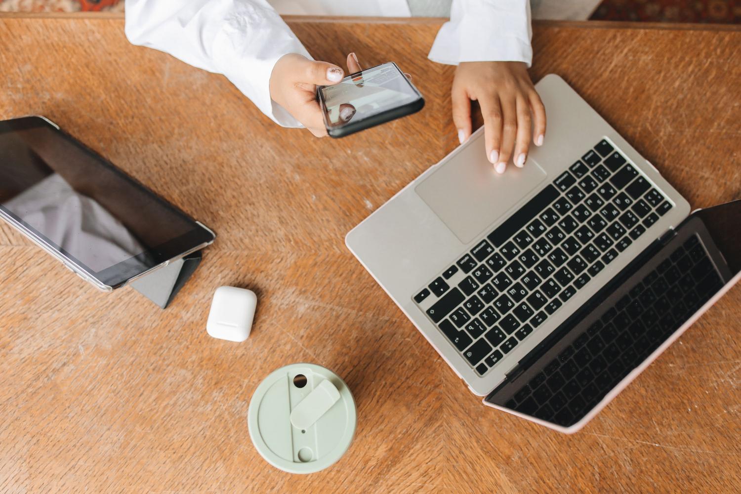 Espacio de trabajo digital con portátil, smartphone y tablet, representando el ecosistema de conectividad actual.