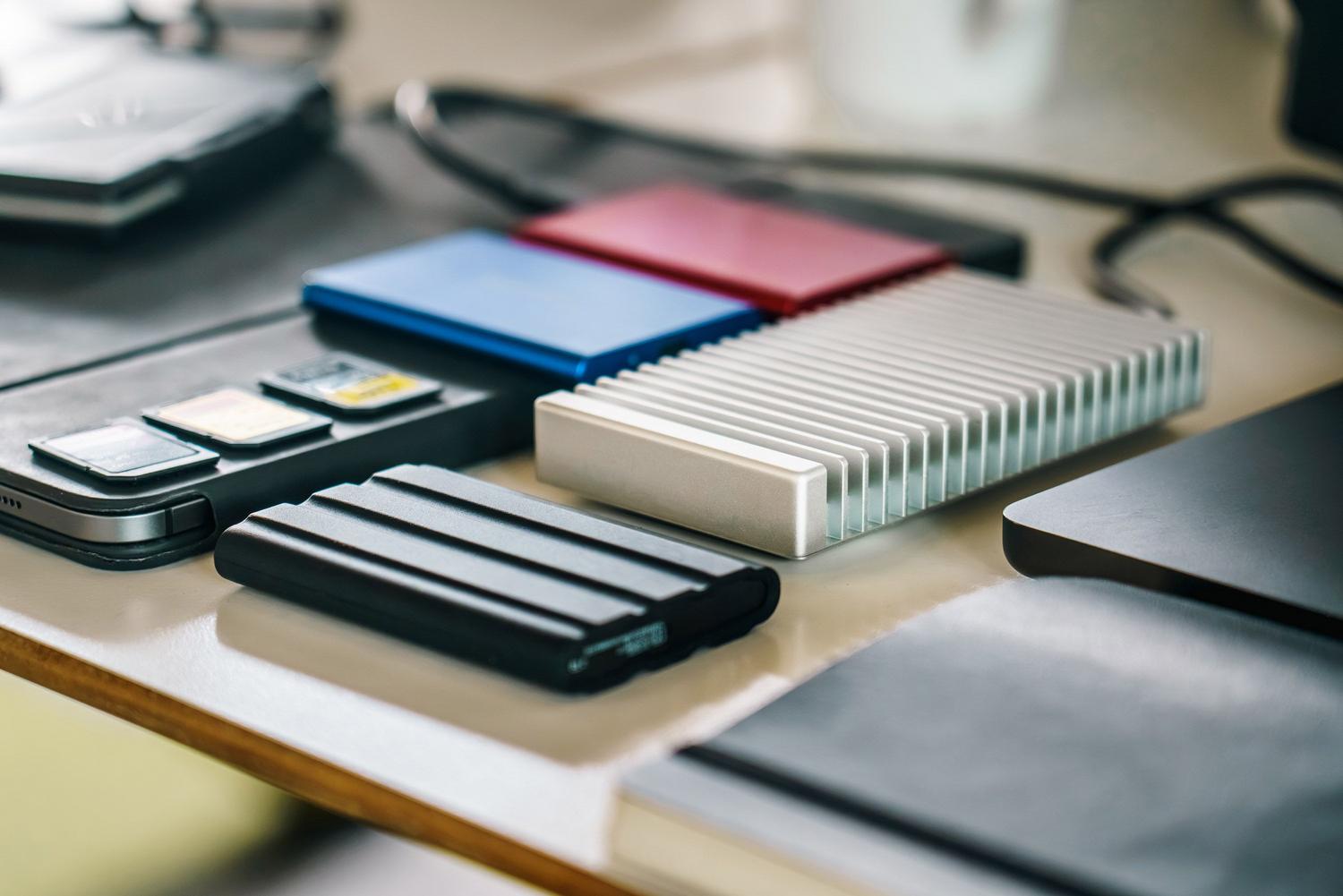 Espacio de trabajo moderno con discos SSD y tarjetas de memoria, ideal para ilustrar la gestión de datos y almacenamiento.