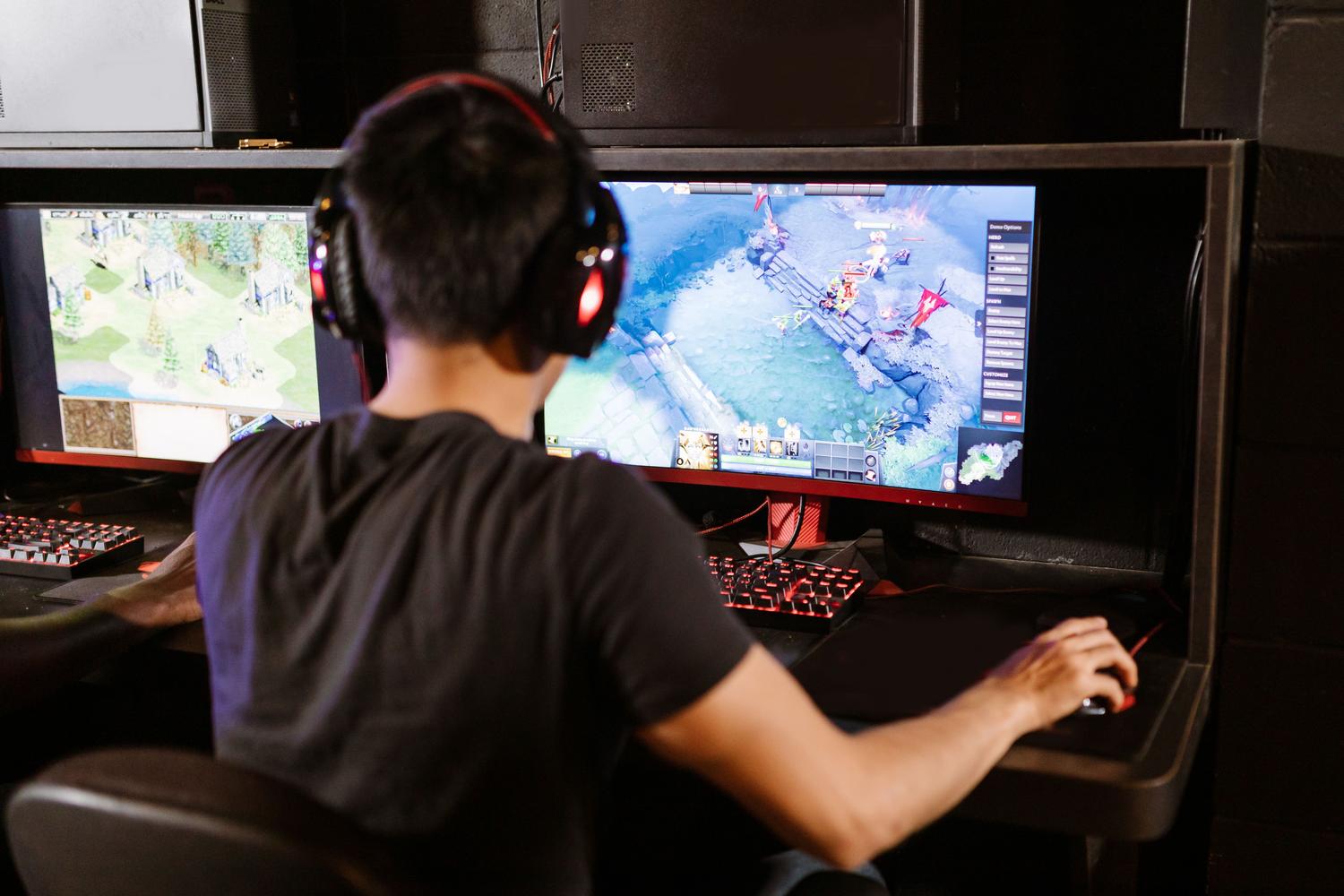 Jugador concentrado frente a un setup de doble monitor, representando la ventaja competitiva de los hercios altos.