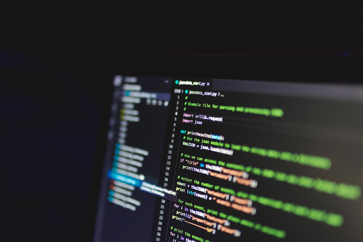 Código de programación en una pantalla de ordenador en un entorno oscuro, simbolizando el proceso de OCR y automatización