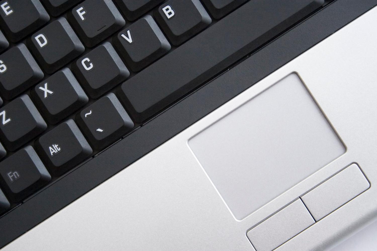 Detalle de un teclado de laptop y touchpad, ideal para representar el uso de claves de acceso en ordenador.