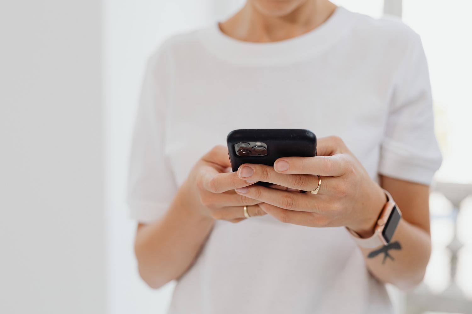 Persona sosteniendo un smartphone en un entorno neutro, ideal para iniciar una guía de búsqueda de Google.