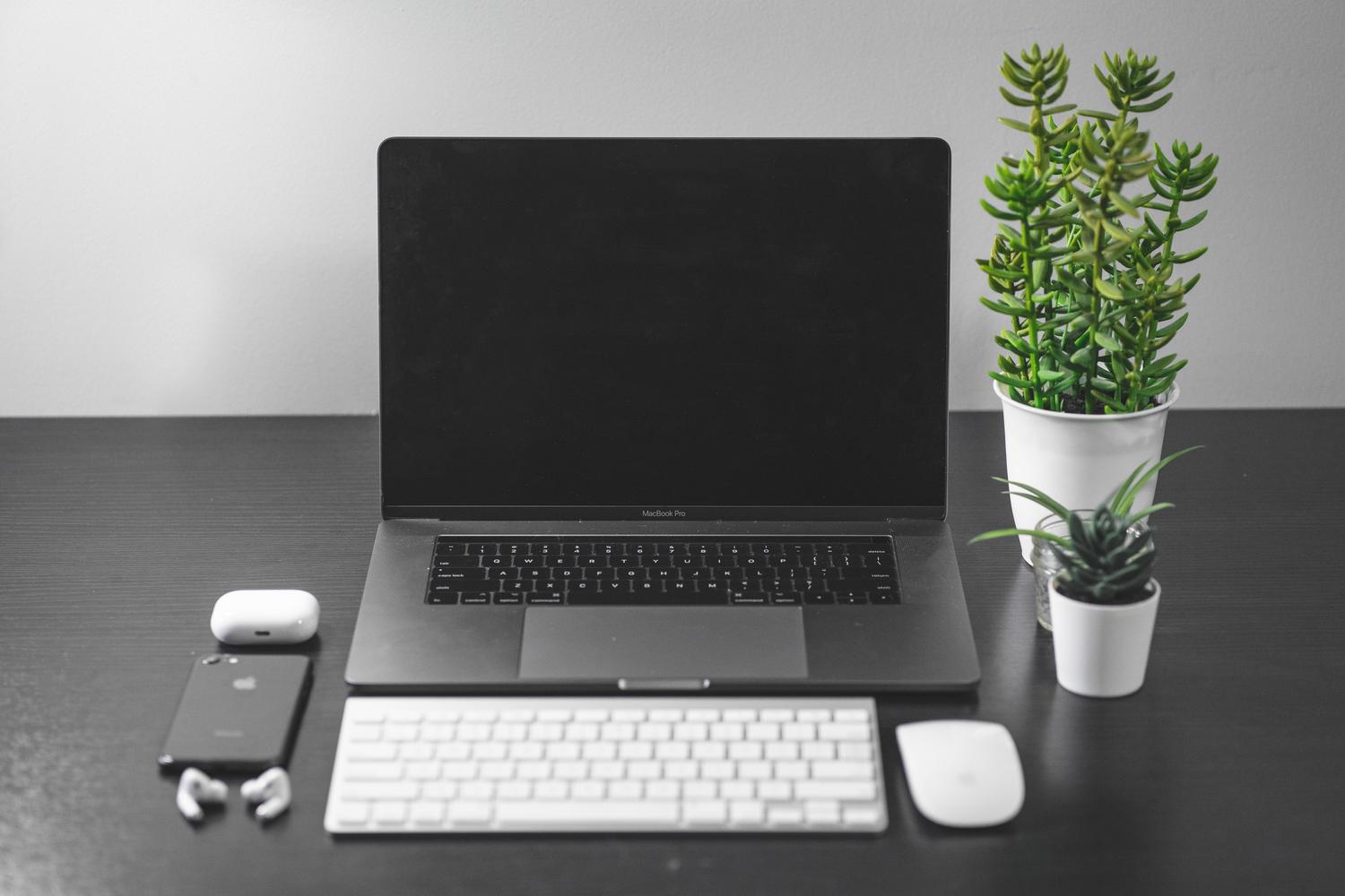 Espacio de trabajo moderno y tecnológico con MacBook y accesorios Apple, evocando un ecosistema de productividad y organización digital.