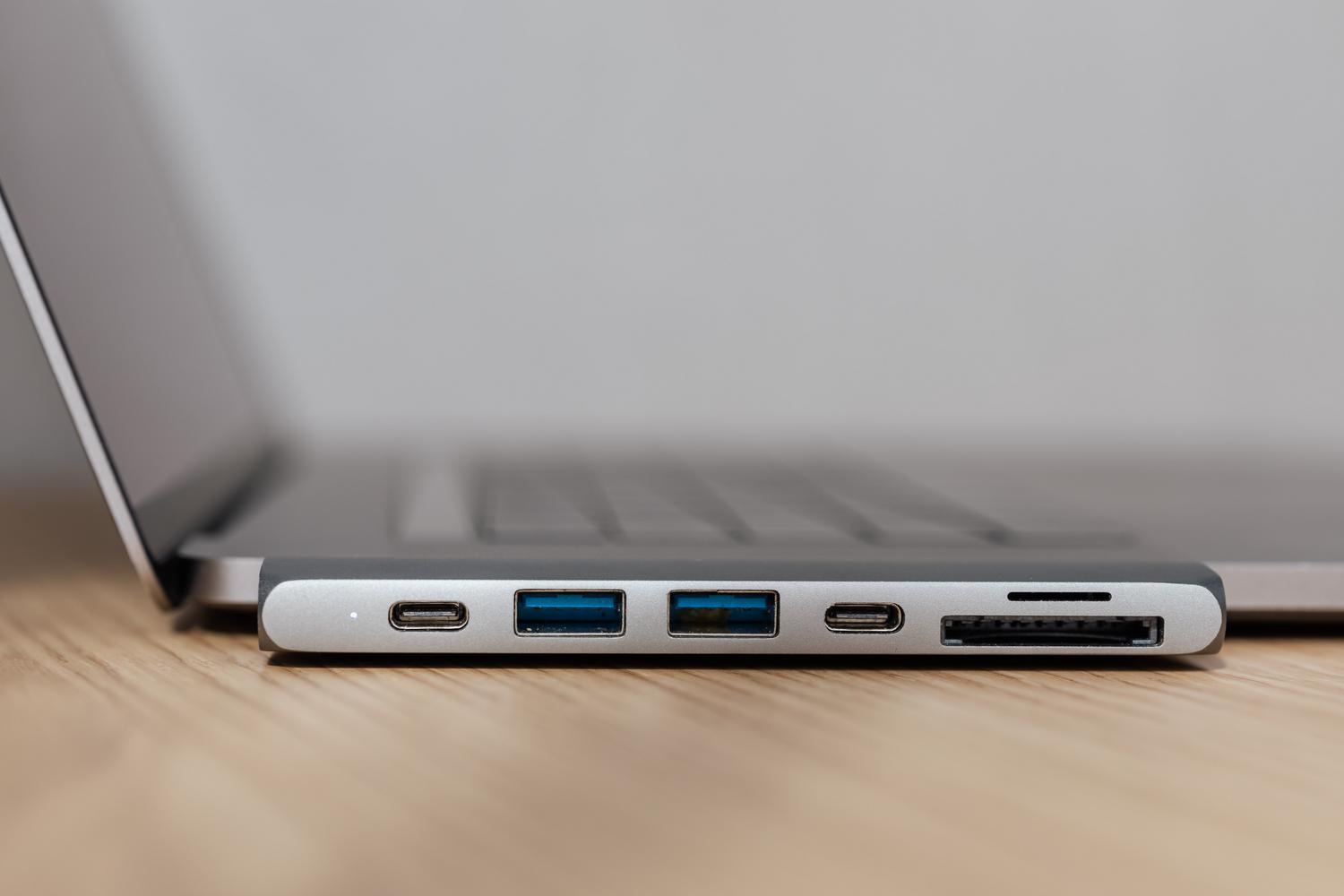 Hub USB-C multipuerto conectado a un portátil, ilustrando la alternativa de usar adaptadores para expandir la conectividad de vídeo.