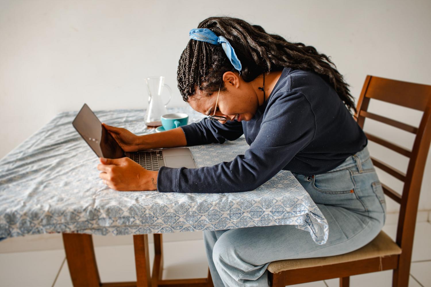 Frustrated woman using a laptop at home, illustrating the annoyance of system errors after a Windows update.