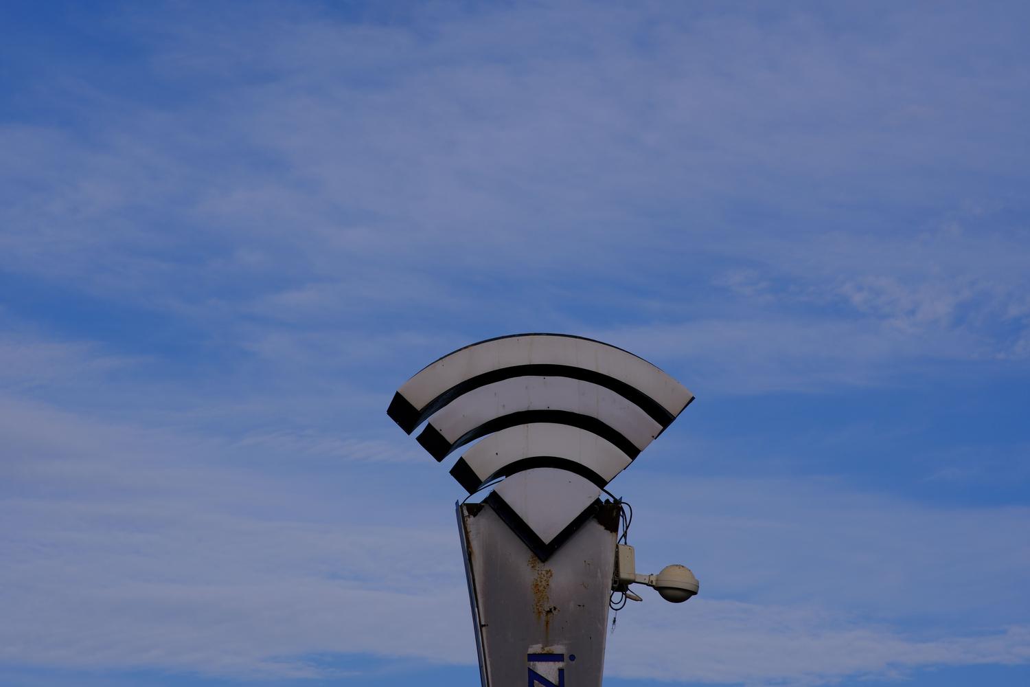 Escultura con la forma del símbolo de WiFi sobre un fondo de cielo azul, sirviendo como ancla visual del tema de conectividad inalámbrica.