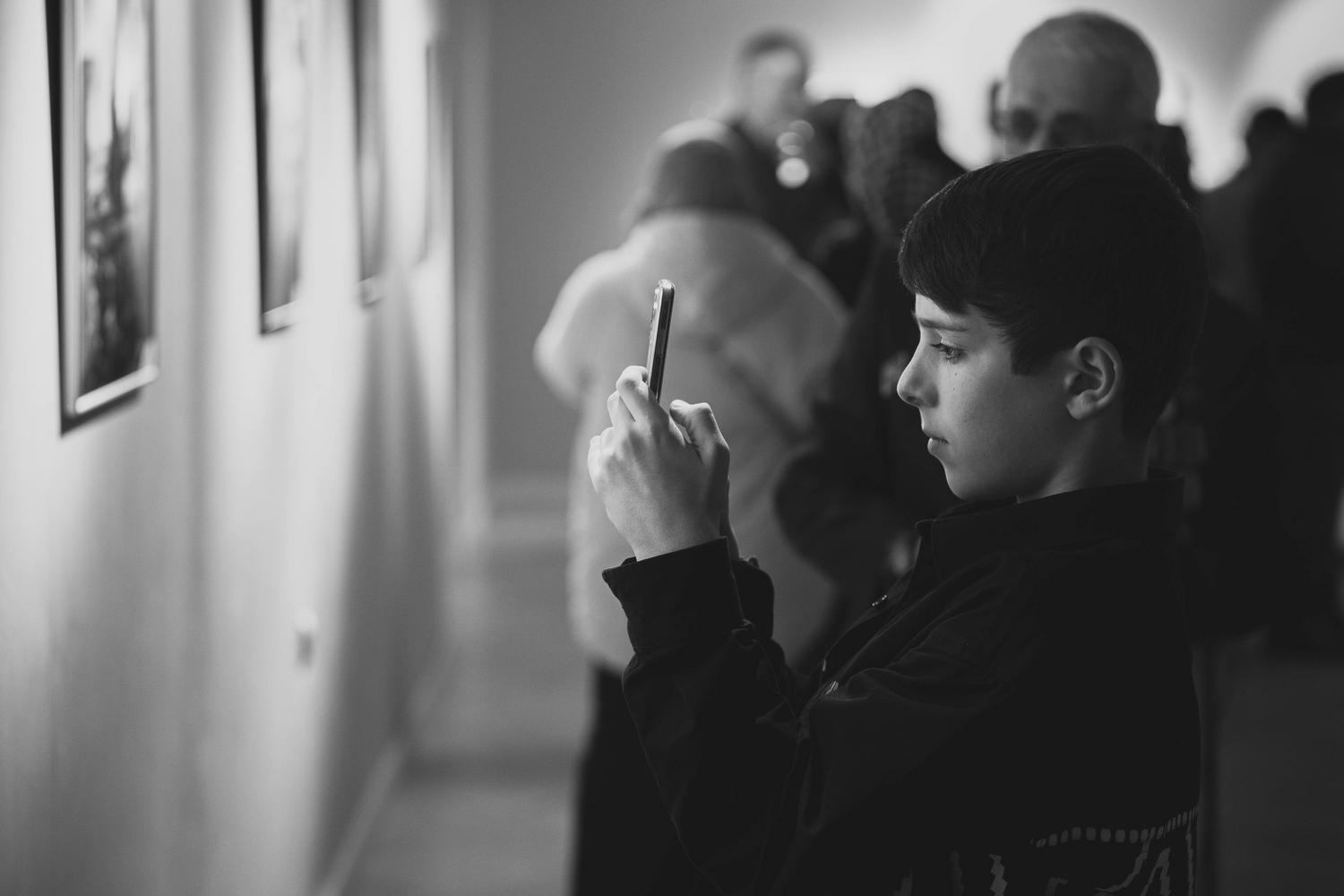 Persona fotografiando una obra de arte en una galería para reconocer la pieza y conocer su contexto