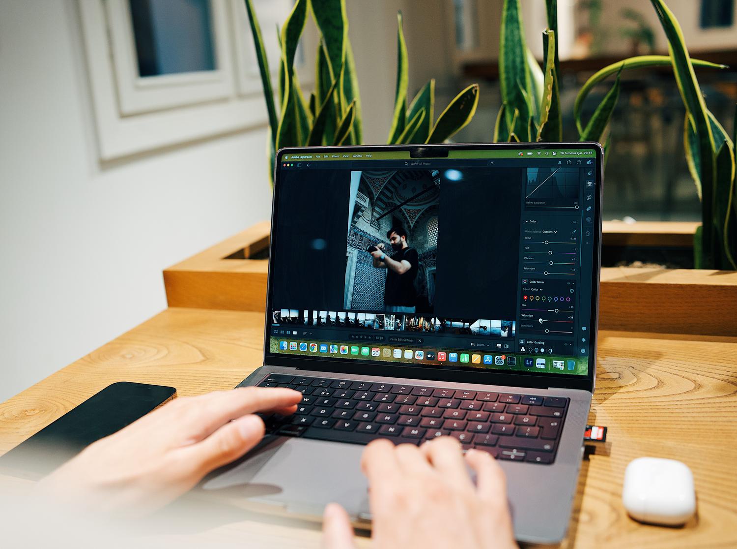Fotógrafo editando imágenes en un ordenador portátil, representando las nuevas capacidades del editor de Fotos de Windows 11.